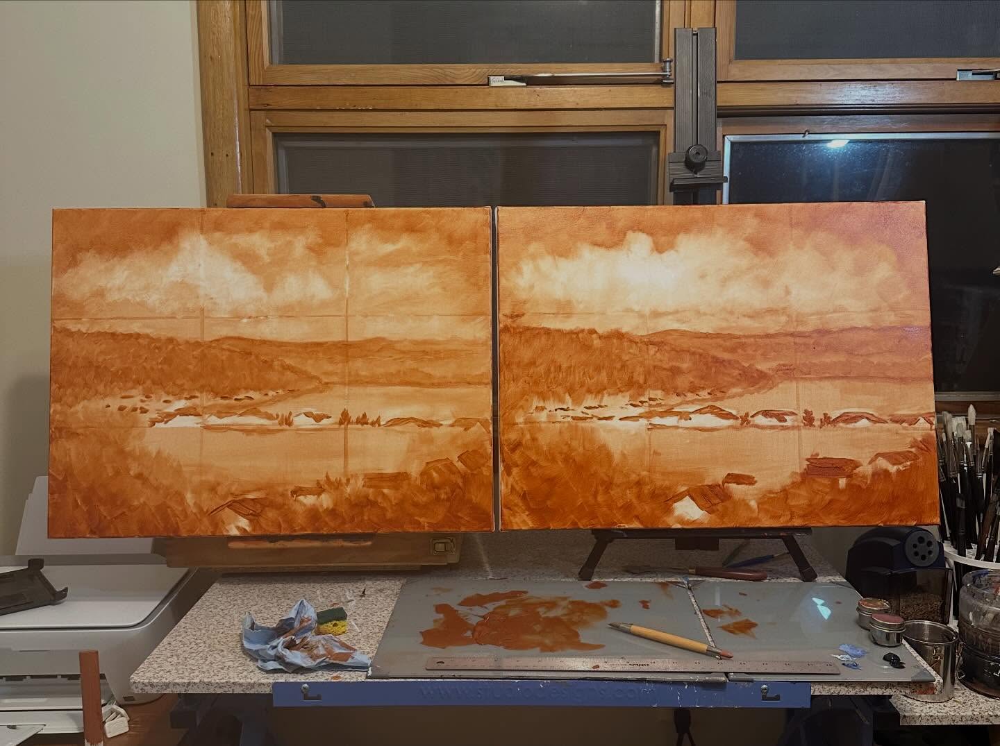 Burnt sienna underpainting diptych of a coastal landscape on easel